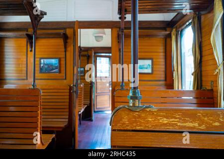 Das Innere eines alten hölzernen Eisenbahnwaggons mit Holzsitzen Stockfoto