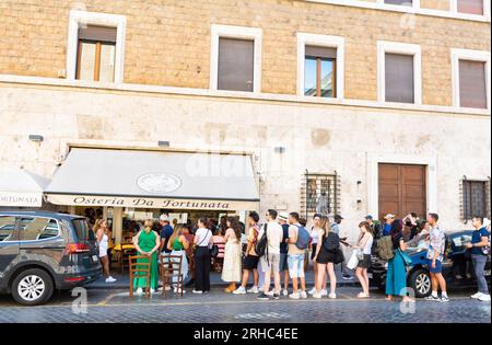 Rom, Latium, Italien, Touristen warten in einer Warteschlange bei Osteria da fortunata, einem berühmten römischen Restaurant für hausgemachte Pasta. Stockfoto