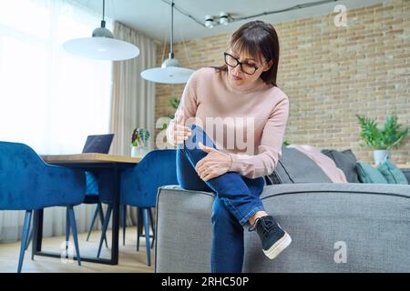 Frau mittleren Alters mit Gelenkschmerzen im Knie Stockfoto