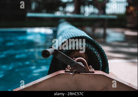 Manuell wirkend für eine einziehbare, schwimmende Poolabdeckung, um Blätter fernzuhalten und Wärme zu halten. Stockfoto