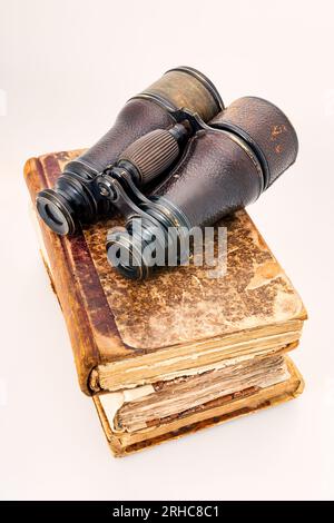 Vintage-Notizbücher aus Leder, antike Notizen und ein Fernglas aus dem letzten Jahrhundert, das Abenteurer und Reisen darstellt. Objekte auf weiß isoliert Stockfoto