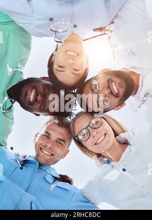 GRUPPE MULTINATIONALER PRAKTIKANTEN, DIE LÄCHELND HINUNTERSCHAUEN Stockfoto