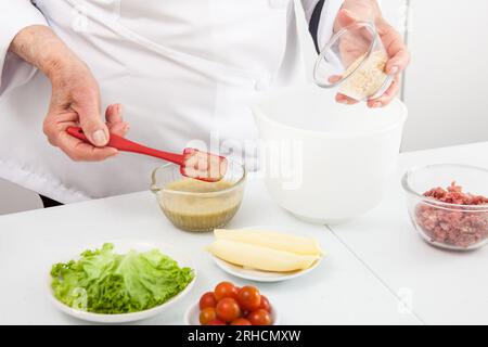 Schrittweise Herstellung von Mini-Burgern. Hausgemachte Mini-Burger für Kinder oder Vorspeisen. Kleine Hamburger. Stockfoto