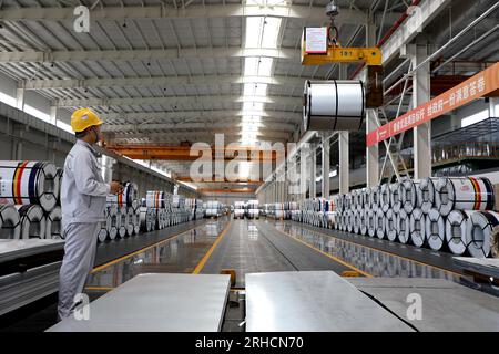 BINZHOU, CHINA – 15. AUGUST 2023 – Lagerpersonal übergibt Stahlrollen an Kunden zur Beladung in Binzhou, Provinz Shandong, China, August Stockfoto