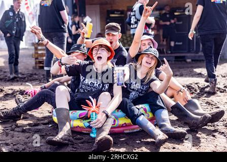 Wacken, Deutschland. 03. Aug. 2023. Festivalbesucher sitzen in einem Swimmingpool vor dem Container des Trash Metal Project auf dem Festivalgelände. In Zusammenarbeit mit den Veranstaltern des Festivals versucht das Trash Metal Project, die Themen Abfallvermeidung und Recycling unter die Metallköpfe zu bringen. (Zu dpa-KORR: 'Festivals wollen nachhaltiger werden - aber wie?') Kredit: Axel Heimken/dpa/Alamy Live News Stockfoto