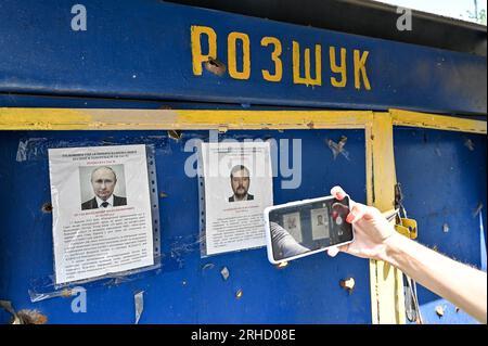 Nicht exklusiv: ORIKHIV, UKRAINE - 10. AUGUST 2023 - Eine Frau fotografiert die Fotos des russischen Präsidenten Wladimir Putin und des russischen Kollaborateurs Stockfoto