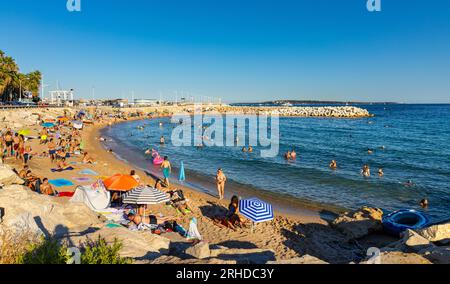 Cannes, Frankreich - 31. Juli 2022: Touristen sonnen sich am Strand Plage du Midi am Mittelmeerküsten der französischen Riviera Azure Stockfoto