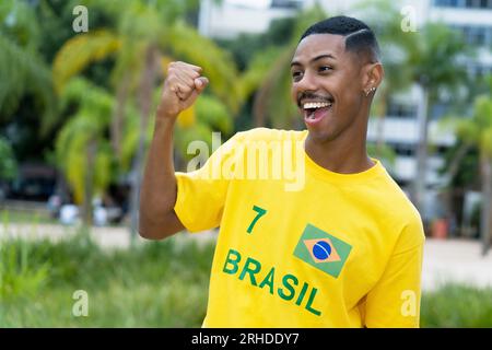 Begeistert ist der junge Mann aus Brasilien mit dem gelben Fußballtrikot im Freien in Bahia Stockfoto