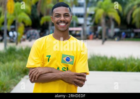 Hübscher junger Mann aus Brasilien mit gelbem Fußballtrikot im Freien in Brasilia Stockfoto