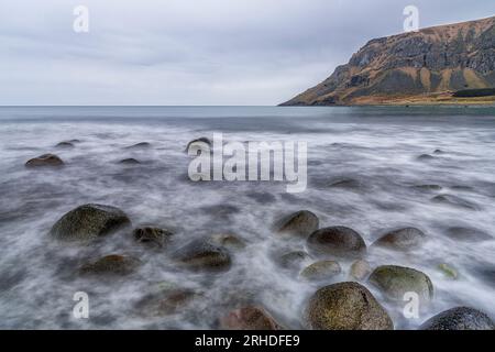 Wellen stürzen auf Felsen in der wilden Landschaft von Unstad Beach, Vestvagoy, Lofoten-Inseln, Norwegen Stockfoto