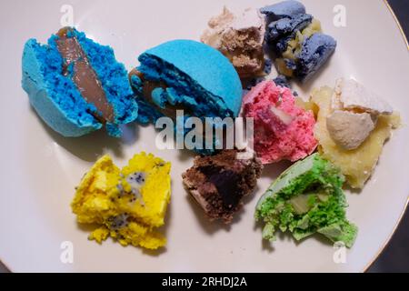 Viele große gebissene Makronen auf einem wunderschönen weißen Teller, auf weißem Hintergrund. Foto für Inhalt. Hochwertiges Foto Stockfoto