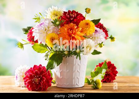 Herbststillleben mit Gartenblumen. Wunderschöner Herbststrauß in Vase auf Holztisch. Bunte Dahlien und Chrysanthemen. Stockfoto