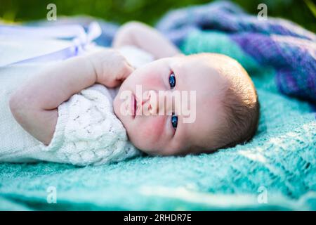 Australisches Mädchen, das draußen auf einer Decke im Garten liegt und schönes Wetter genießt Stockfoto