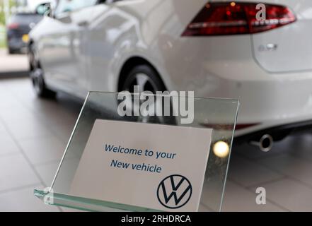 Neuwagenkauf, Abholung eines neuen weißen Autos aus dem VW Showroom, Volkswagen Golf GTI MK7 3-türiger Benziner mit Heckklappe Stockfoto