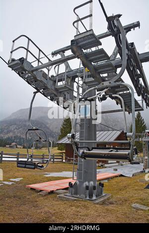 Frühlingslandschaft in einem Skigebiet außerhalb der Saison in der Nähe von Cima Sappada in Carnia, Udine, NE Italien. Leere Sessellifte und ein Zwischenturm Stockfoto