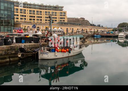 Ein Fischerboot legte im alten Dock an („Vecchia Darsena“) mit der Priamar-Festung (1542) im Hintergrund im Winter, Savona, Ligurien, Italien Stockfoto