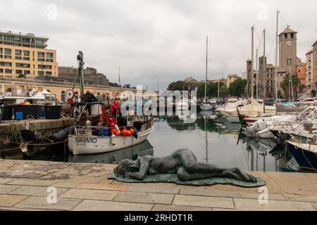 View of the Old Dock with the statue 'Sleeping Mermaid' and the medieval towers Brandale, Corsi and Scolopi in the background, Savona, Liguria, Italy Stock Photo