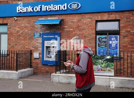 Eine Person übergibt einen außer Betrieb befindlichen Geldautomaten bei einer Zweigstelle der Bank of Ireland im Dorf Finglas, Dublin. Die Bank of Ireland hat sich entschuldigt, nachdem ein Fehler dazu geführt hat, dass einige ihrer Kunden mehr Geld abheben oder überweisen als auf ihren Konten vorhanden war. Die Bank erklärte, dass dies auf ein technisches Problem mit ihren Services und nicht auf einen Cyberangriff zurückzuführen sei. Bilddatum: Mittwoch, 16. August 2023. Stockfoto