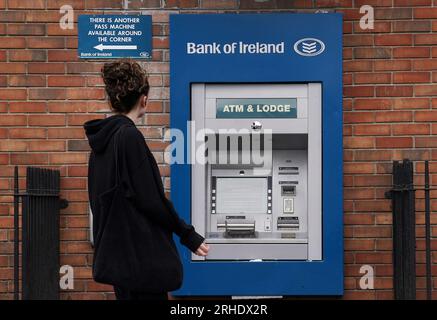 Eine Person übergibt einen außer Betrieb befindlichen Geldautomaten bei einer Zweigstelle der Bank of Ireland im Dorf Finglas, Dublin. Die Bank of Ireland hat sich entschuldigt, nachdem ein Fehler dazu geführt hat, dass einige ihrer Kunden mehr Geld abheben oder überweisen als auf ihren Konten vorhanden war. Die Bank erklärte, dass dies auf ein technisches Problem mit ihren Services und nicht auf einen Cyberangriff zurückzuführen sei. Bilddatum: Mittwoch, 16. August 2023. Stockfoto