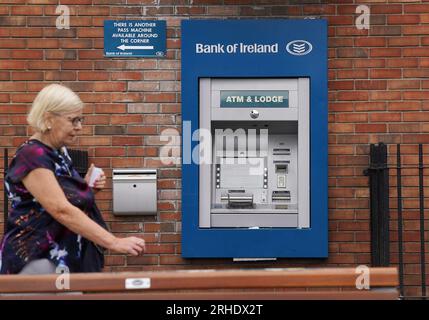 Eine Person übergibt einen außer Betrieb befindlichen Geldautomaten bei einer Zweigstelle der Bank of Ireland im Dorf Finglas, Dublin. Die Bank of Ireland hat sich entschuldigt, nachdem ein Fehler dazu geführt hat, dass einige ihrer Kunden mehr Geld abheben oder überweisen als auf ihren Konten vorhanden war. Die Bank erklärte, dass dies auf ein technisches Problem mit ihren Services und nicht auf einen Cyberangriff zurückzuführen sei. Bilddatum: Mittwoch, 16. August 2023. Stockfoto