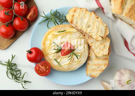 Leckerer gebackener Brie-Käse auf weißem Marmortisch, flach liegend Stockfoto