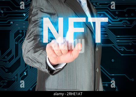 Geschäftsmann, der auf die virtuelle NFT-Taste drückt, bei Nahaufnahmen des digitalen Hintergrunds Stockfoto