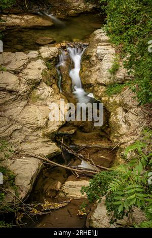 Fluss Riera de la Malatosca, zwischen Felsen hinuntergehend, auf dem Weg zum Dorf Sant Joan de les Abadesses, Ripollès, Girona, Katalonien, Spanien, Pyrenäen Stockfoto