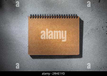 Draufsicht auf Hardcover-Kraftpapier-Notizbuch für Mockup oder Hintergrund mit Kopierplatz Stockfoto