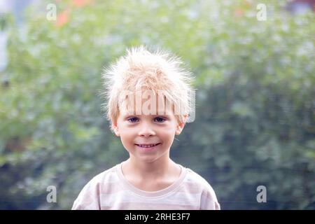 Süße kleine Jungen mit statischen electricy Haar, in seiner komischen Porträt im Freien auf einem Trampolin genommen Stockfoto