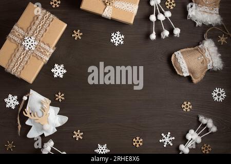 Weihnachtsgeschenke und Dekorationen aus natürlichen Materialien auf einem dunklen Holztisch mit Kopierraum. Mockup für Karten und Werbung. Stockfoto