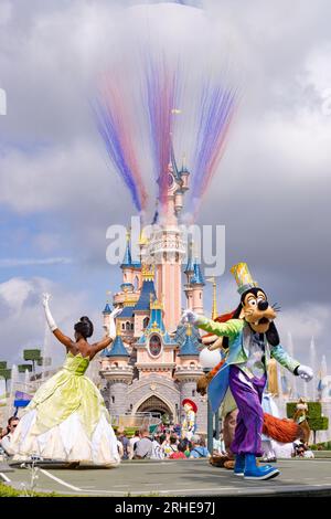 Disneyland Paris Parade und Charaktere tanzen vor dem Disneyland Castle Feuerwerk, mit Goofy und Prinzessin Tiana; Disney Paris Frankreich Stockfoto