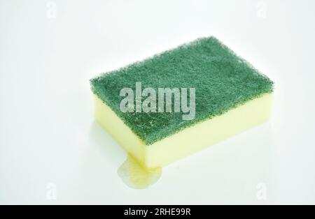 Gelber und grüner Scheuerschwamm mit flüssigem Waschen auf weißem Hintergrund Stockfoto