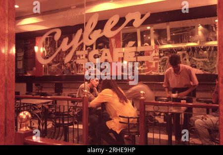 Ein Cyber-Café auf einer Straße mit Geschäften und Verkehr in der Stadt Bangalore in der Provinz Karnataka in Indien. Indien, Bangalore, April 1998 Stockfoto