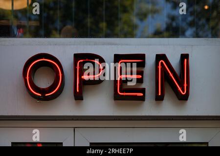 Ein rotes Neon vor einem Restaurant, das „Open“ sagt. Stockfoto