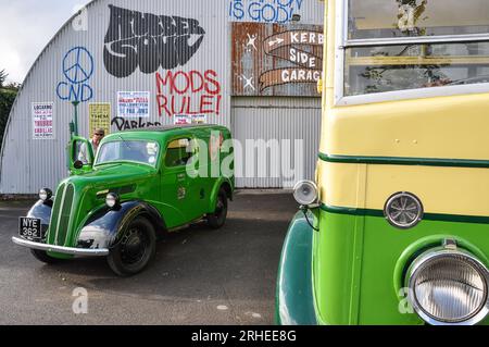 Re-creation of a 1950s or 1960s garage scene with 1953 Ford Popular van being cleaned. Vintage graffiti painted on wall. Mods rule. CND symbol Stock Photo