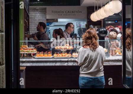 Donostia-San Sebastian, Spanien - 15. September 2022: Frau wartet auf ihre Essensbestellung im Restaurant Pintxos Stockfoto