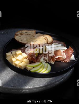 Platte mit Aufschnitt mit Käse, saurem Apfel, serrano-Schinken mit Oliven, geröstetem Brot, mexiko-lateinamerika Stockfoto