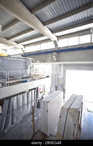 Mann in Steinschneidewerk/Werkstatt. Steinmine. Marmormine. Edelsteinschneidwerk. Mann schneidet großen weißen Stein. Marmorbrüche. Stockfoto