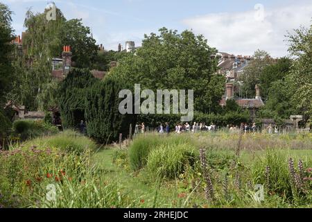 Eine Hochzeitsgesellschaft versammelt sich in Southover Grange Gardens, nachdem sie das Kasse hinter den Eibenbäumen besucht hat. Stockfoto