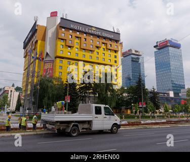 Arbeiter und Minibus vor dem Hotel Holiday Ex Holiday Inn. Entwickelt für die Olympischen Winterspiele 1984. Sarajevo, Bosnien und Herzegowina, 16. August 2023. Stockfoto