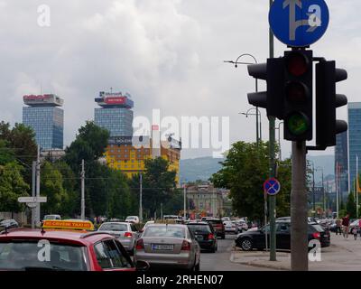 Vor dem gelben Hotel Holiday Ex Holiday Inn ist viel Verkehr. Entwickelt für die Olympischen Winterspiele 1984. Sarajevo, Bosnien und Herzegowina, 16. August 2023. Stockfoto