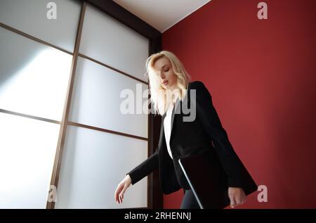 Junge Erwachsene Geschäftsfrau trägt formalwear und trägt den Laptop Stockfoto