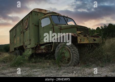 Old Rusty, Greenish, Army Truck Oder Transporter Auf Dem Feld Bei Sunset Stockfoto