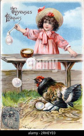 Carte de voeux pour Paques : une poule couvant ses oeufs regarde avec curiosite les bulles de savon faites par une petite fille - Carte postale datee 1900-1909 Stockfoto