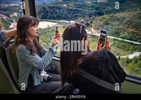 Asiatische Touristen in der cremallera Rack Eisenbahnbahn, die den Berg Montserrat, Monistrol de Montserrat, Barcelona, Spanien erklimmen. Der Montserrat r Stockfoto