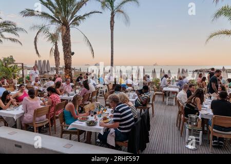 Tourists dining in a restaurant next to Larvotto beach in Monte Carlo Stock Photo