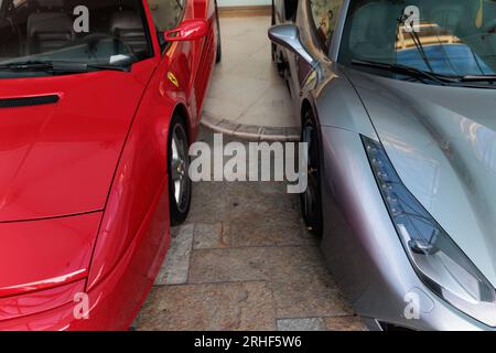 Ferrari Testarossa (left) and Ferrari 488 (right) side by side in a parking lot Stockfoto
