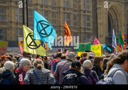 LONDON - 22. April 2023: Extinction Rebellion's mächtige Botschaft: Demonstranten mit Fahnen und Fahnen versammeln sich vor den Häusern des Parlaments in Lon Stockfoto