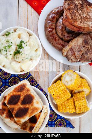 Südafrikanischer Braai-Tag oder Heritage Day. Traditionelles Braai-Essen wird gefeiert. Fleisch und Beilagen mit traditionellem Shwe - Shwe Tuch. Stockfoto