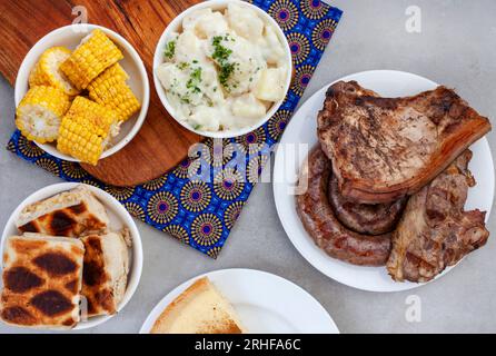 Südafrikanischer Braai-Tag oder Heritage Day. Traditionelles Braai-Essen wird gefeiert. Fleisch und Beilagen mit traditionellem Shwe - Shwe Tuch. Stockfoto